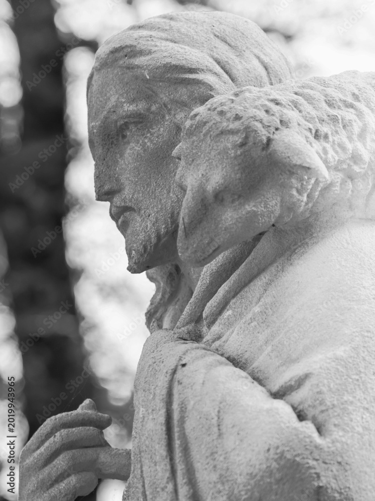 Fototapeta premium Black and white statue of Jesus Christ carrying lost sheep