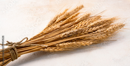 Foto Wheat spikelets on a white stone background.