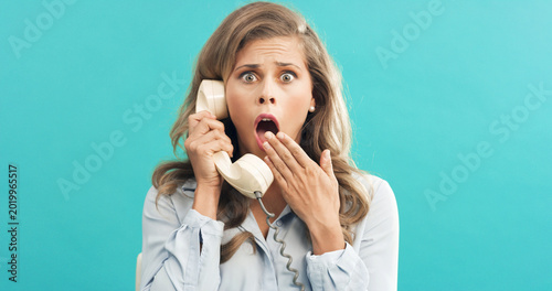 Cuadro en lienzo Woman, portrait or shock with retro telephone for terror, fear or news on a blue studio background