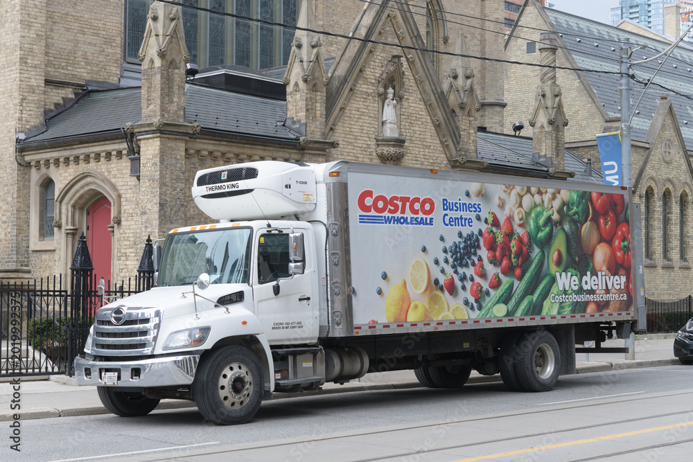 Fototapeta premium Costco Business Centre refrigerated delivery truck stopped outside the east facade of St Michael's Cathedral Basilica (Church St side), Toronto