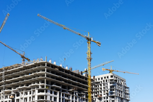 Midrise construction site with tower cranes, sustainable urban development progress