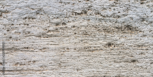 Foto Texture of natural travertine or limestone tufa with a porous structure
