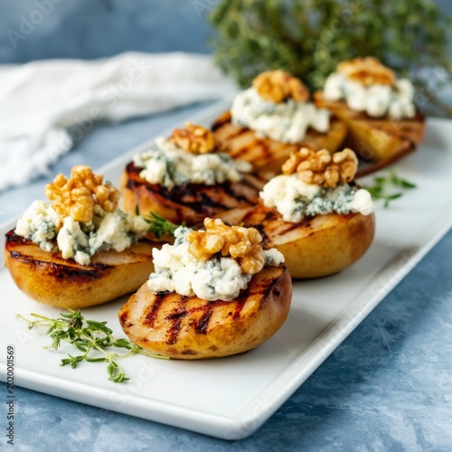 Grilled Peaches Filled With Cheese and Walnuts Served on a Platter With Herbs...