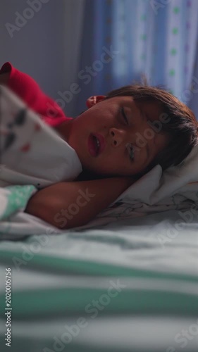Young boy sleeping peacefully in bed at home resting after day concept of comfort security and healthy childhood routine