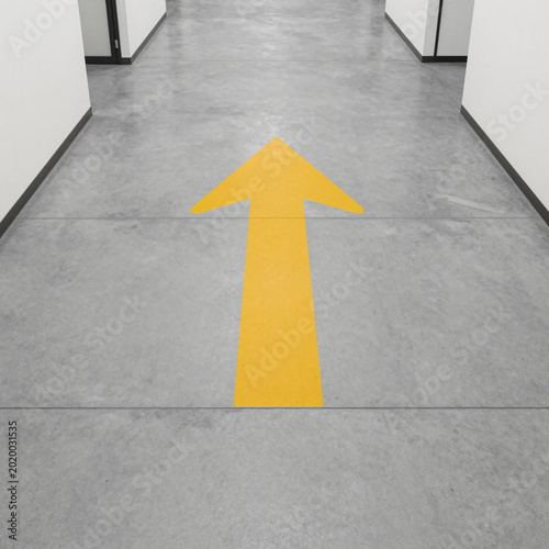 Yellow directional arrow on polished concrete office floor