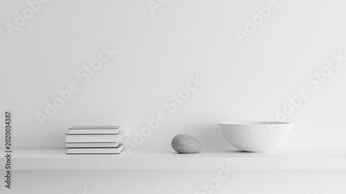 Minimalist shelf display with books, stone, and bowl