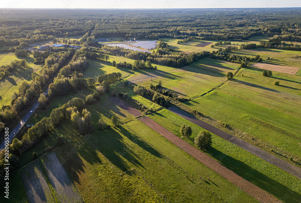 Fototapeta premium Aerial view of fields, meadows and solar panels farm near Lochow town, Poland