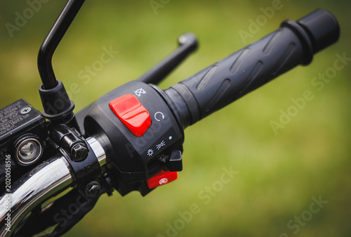 Tableau sur toile Close up of a motorcycle handlebar with a red engine kill switch and black rubbe