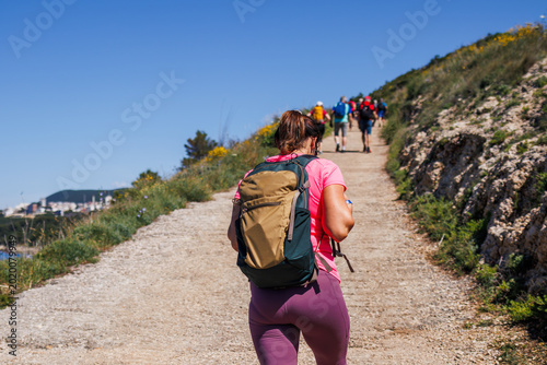 Quadro su tela Woman tourist with backpack hiking uphill on trekking trail to Ulcinj in Montenegro
