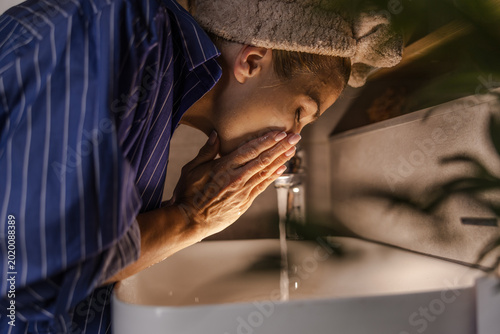 Woman Washes Her Face at Home in the Bathroom During Morning Routines to Start the Day Fresh and Clean