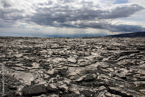 Fotografija Expansive field of hardened pahoehoe lava under a dramatic cloudy sky in Hawaii
