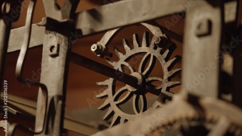 A close-up shot of the mechanical gears of a grand clock inside a German castle, swinging back and forth