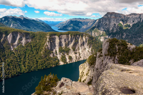 Panoramic view of a deep blue lake surrounded by massive granite walls at Mirada del Doctor lookout.