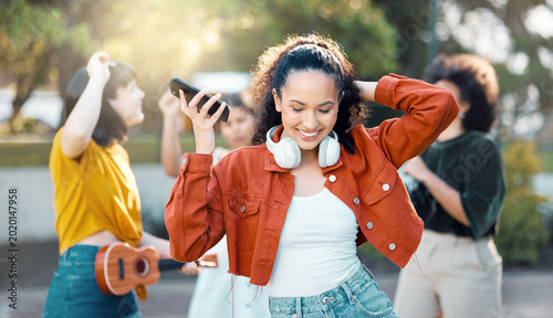 Dance, music and woman with friends for outdoor fun, celebration and happy for phone playlist. Listening, audio and people with song, happiness and streaming for gathering, bonding and group hangout