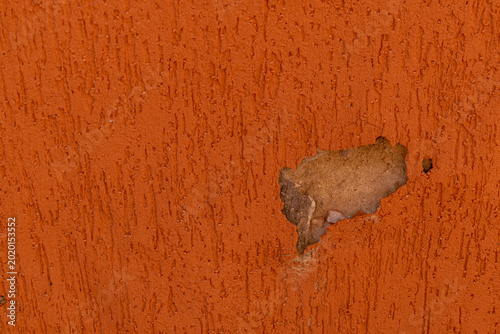 Orange grainy wall with hole. Background. Horizontal image. Space for advertising.