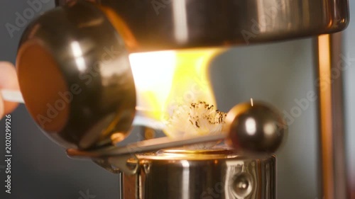 lighting the wick of a Victorian era coffee maker