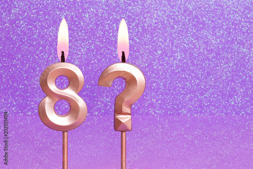 Number 8 and question mark on a pink background with blurred bright dots - Birthday or anniversary card with abstract blurred dots that glow