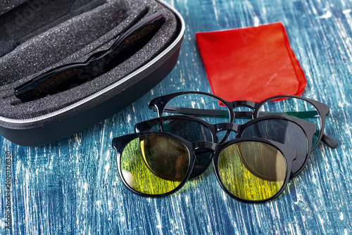 Foto Polarized Sunglasses With Magnetic Clip On Lenses Arranged On Blue Wooden Surfac
