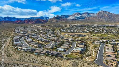 Canvas Print Aerial Nevada Neighborhood with Snowcapped Red Rock Mountains and Desert Landsca
