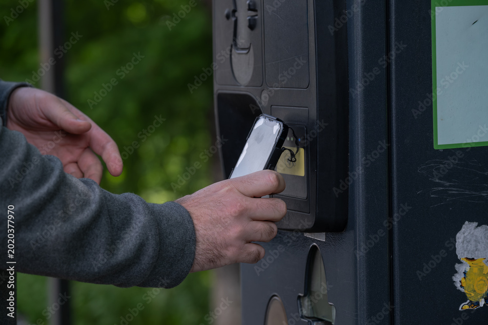 Obraz premium Person using smartphone for contactless parking payment