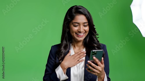 Young Indian Woman Reacts to Smartphone Content with Joy and Surprise.