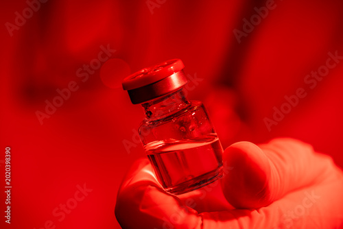 Canvas-taulu emergency medical research: healthcare worker holding a vial in red warning ligh