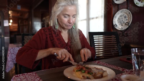 Mature woman eats a meal in a local restaurant while on a trip to Santa Rosalia in Baja California Sur, Mexico.