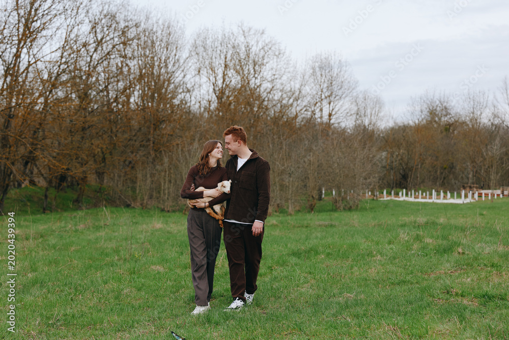 Obraz premium Candid scene of a couple walking in a green field, embracing and sharing a warm moment under cloudy skies, showcasing lifestyle, affection, and connection in a relaxed outdoor setting calm