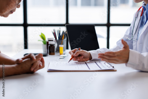 Doctor discussing treatment plan with senior patient  explaining medication and healthcare options during a medical consultation in clinic office