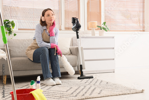 Thoughtful female janitor w...