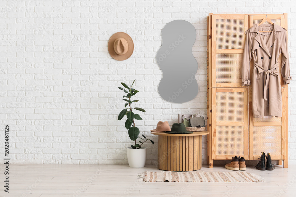 Obraz premium Interior of stylish hallway with mirror, closet and table