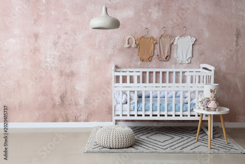 Interior of children s room with crib  table and baby bodysuits