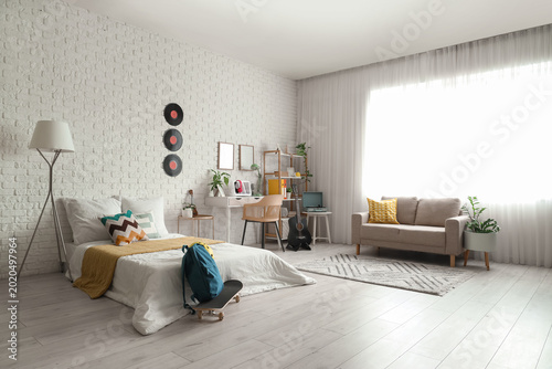 Interior of teenager's room with guitar, workplace and bed