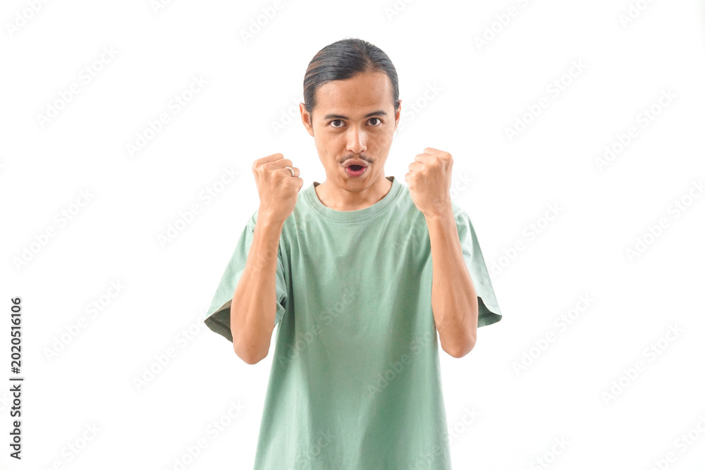 Naklejka premium young handsome Indonesian, Asian man in green shirt positive expression, joyful and exciting isolated on white background. Happy adorable glad man rejoices success