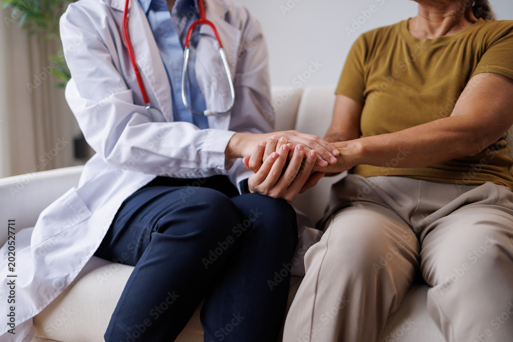 Fototapeta premium Doctor showing care and compassion for a senior patient, holding her hands to offer support and reassurance while discussing health concerns during a medical visit