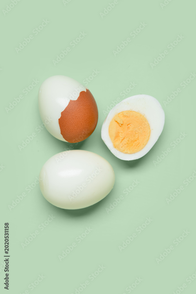 Obraz premium Tasty boiled eggs with half on green background