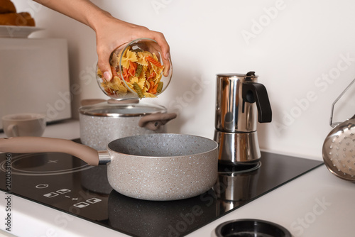 Young man cooking pasta in ...