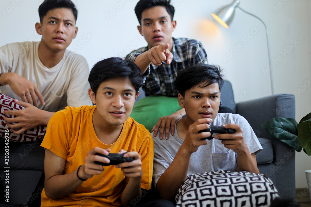 Obraz premium Group of Focused Young Men Playing Video Games Together at Home