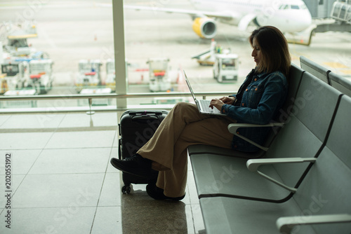 Canvastavla Businesswoman working on her computer with the runway in the background
