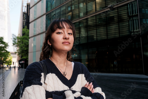 Young woman with confidence crossing arms in city street