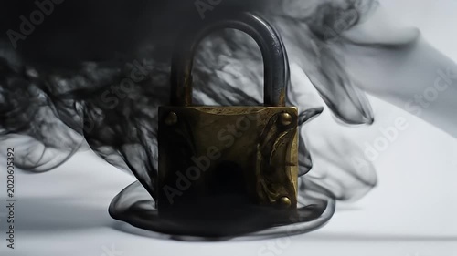 Vintage brass padlock engulfed in mysterious swirling black smoke