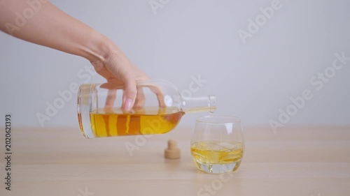 man pour whiskey into a glass on table, suffering from alcohol addiction, alcoholism concept. depicting emotional distress, depression, substance abuse problem, unhealthy lifestyle and mental health