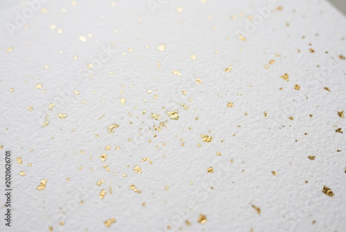 Scattered Golden Confetti on a White Background.