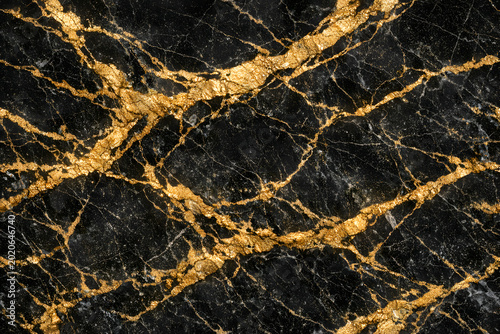 Close up of luxurious black marble surface with striking gold veining showcasing elegant natural patterns and textures suitable for upscale interior design and decorative