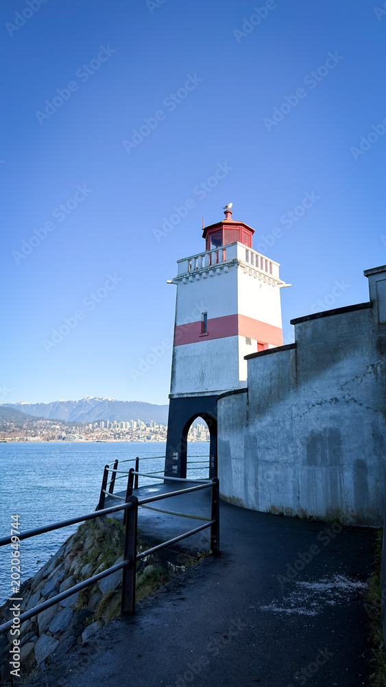 Fototapeta premium Brockton Point Lighthouse in Stanley Park with North Vancouver skyline