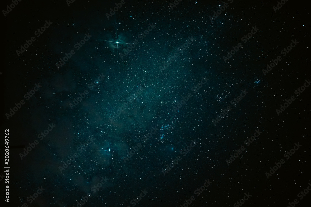 Fototapeta premium Teal star field in dark space with glowing dust and nebula haze
