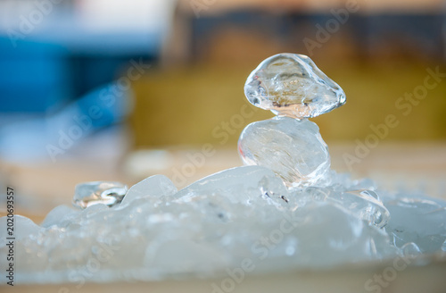 Fotografie Stacked blocks of clear ice with a single, distinct block resting on top