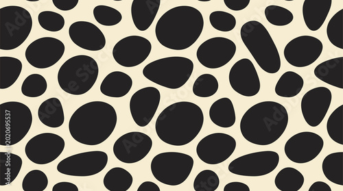 Photos Seamless pattern with random black rounded pebble shapes on a light cream backgr