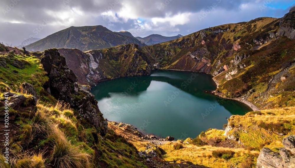 Obraz premium Serene mountain lake in rugged landscape.