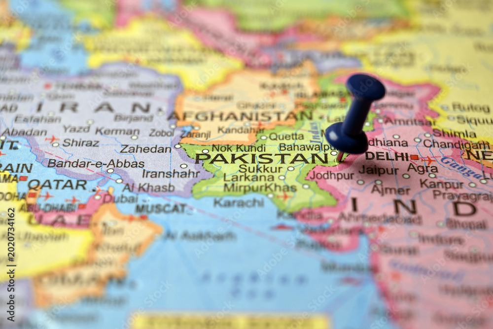 Obraz premium Blue Push Pin Highlighting Pakistan on Paper World Map Macro Close Up with Soft Blurred Background
